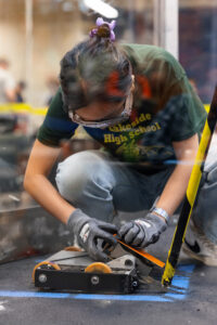 Girl adjusting bot in cage 1